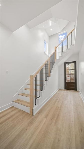 Grand entryway featuring high ceilings, LVP floors, and a spectacular stair case.