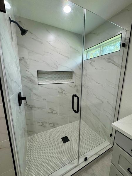 Large walk-in shower with natural lighting.