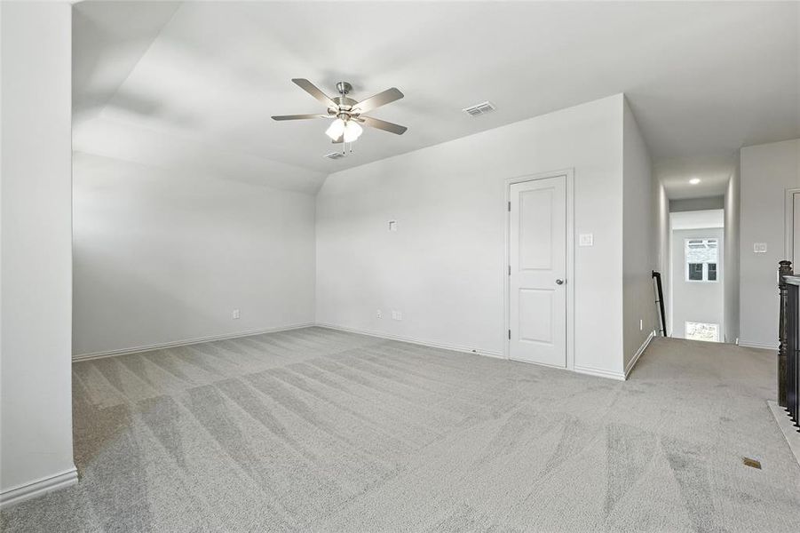 Carpeted spare room with ceiling fan and baseboards Carpeted spare room with ceiling fan and baseboards