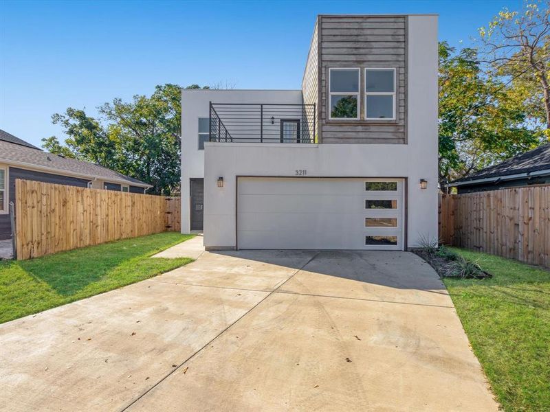 Contemporary house with a patio area, a garage, and a front yard