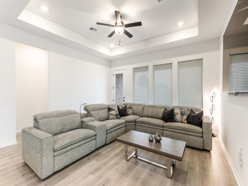 The spacious living room features a tray ceiling, recessed lighting, and plenty of room to stretch out.