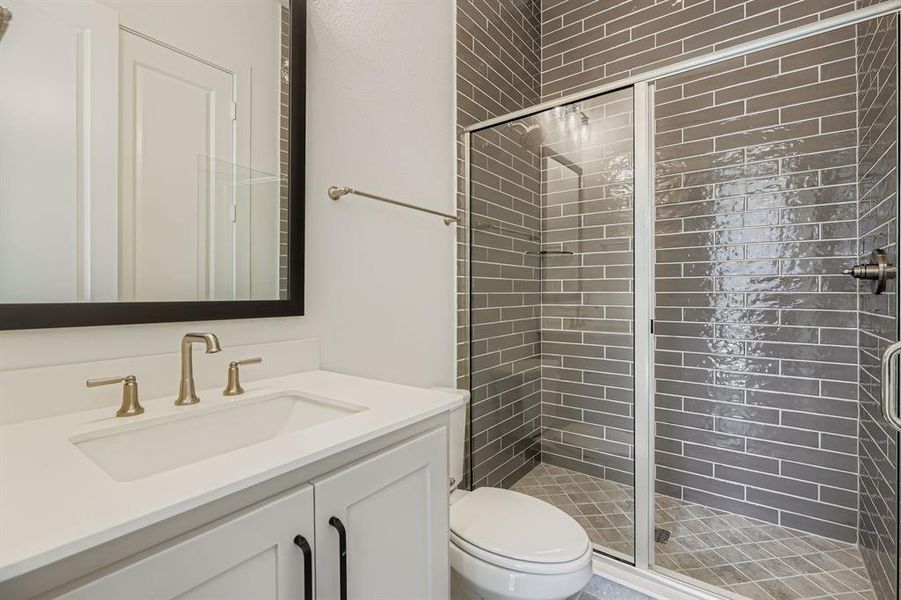 Full bath featuring a stall shower and vanity