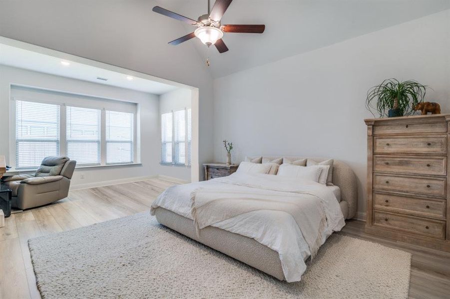 Bedroom with ceiling fan, lofted ceiling, wood finished floors, and baseboards Bedroom with ceiling fan, lofted ceiling, wood finished floors, and baseboards