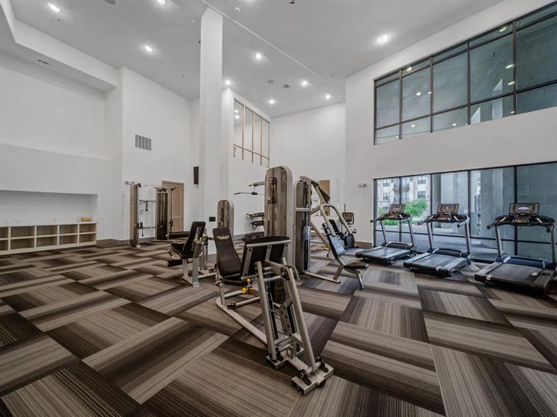 Workout area with carpet, a towering ceiling, and recessed lighting