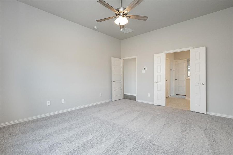 Unfurnished bedroom with ceiling fan and light carpet