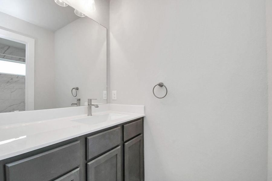 Secondary bathroom. Bath/shower combo with tile surround, dark wood cabinets complete with a beautiful light countertop, this bathroom combines style and functionality for a truly inviting ambiance. Sample photo of completed home with similar floor plan. Actual colors and selections may vary. Secondary bathroom. Bath/shower combo with tile surround, dark wood cabinets complete with a beautiful light countertop, this bathroom combines style and functionality for a truly inviting ambiance. Sample photo of completed home with similar floor plan. Actual colors and selections may vary.