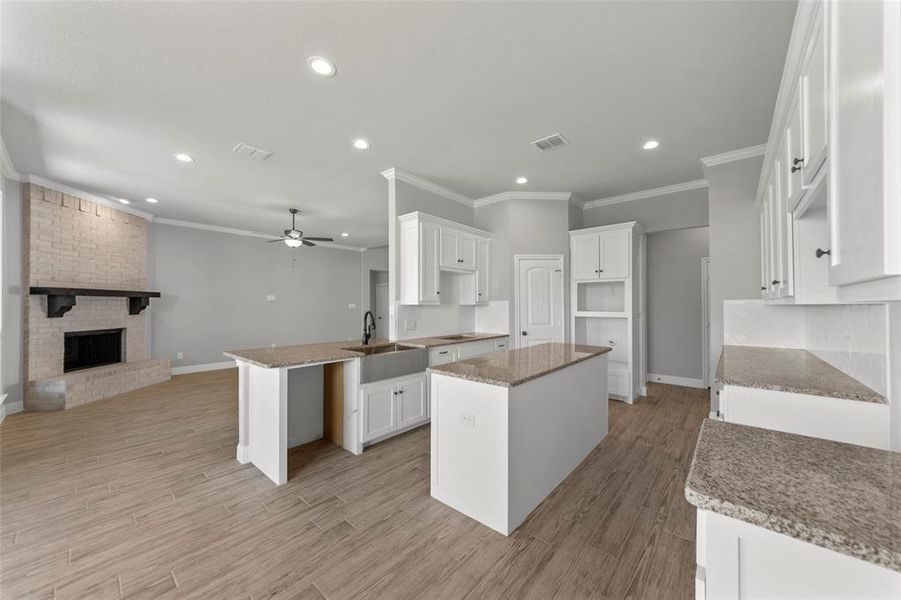 Kitchen featuring a center island, kitchen peninsula, white cabinets, and light hardwood / wood-style floors