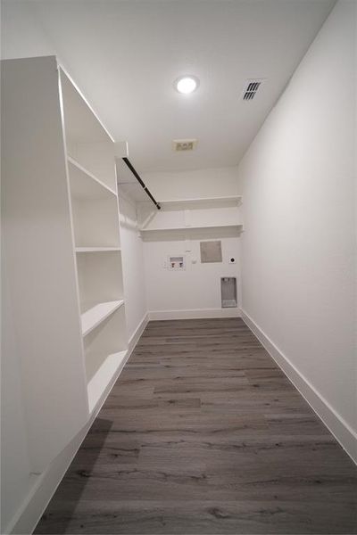 Spacious closet with dark wood-style floors