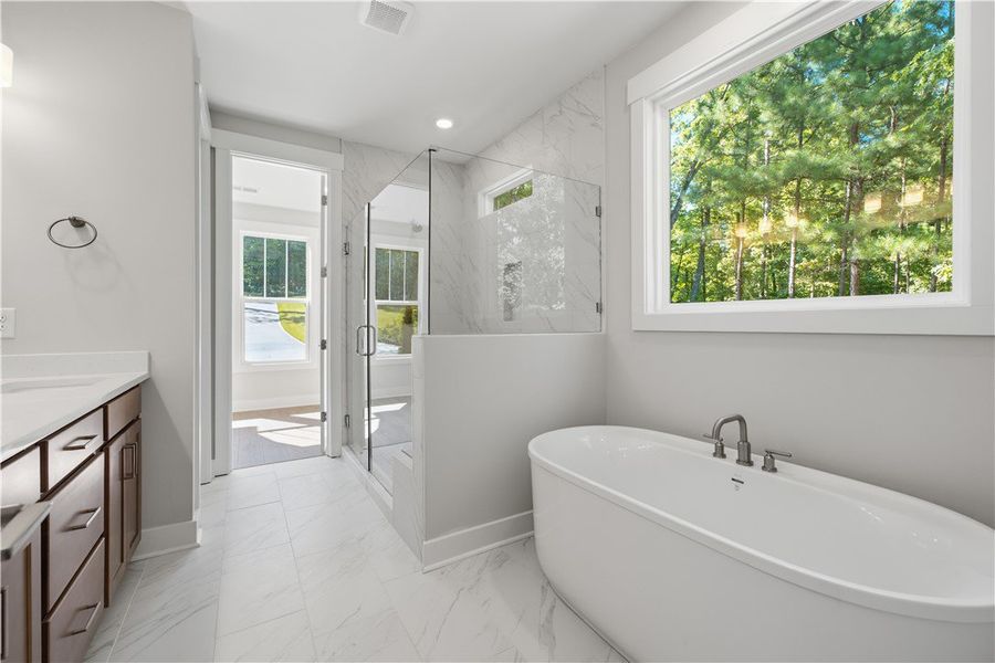Sleek tile floors, a glass-enclosed shower, and a