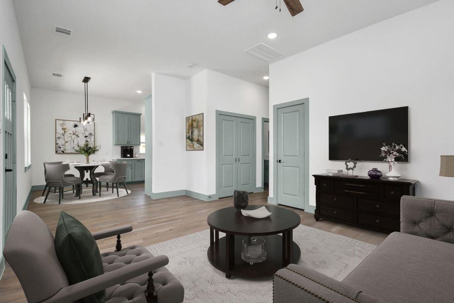 Ample living area complete with a coat closet, celling fan, recessed lights & window blinds. Double doors shown are the laundry area, including a washer and dryer.