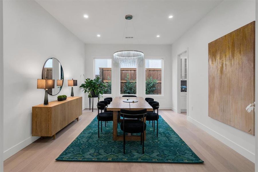 Dining room with light wood-style floors, baseboards, and recessed lighting