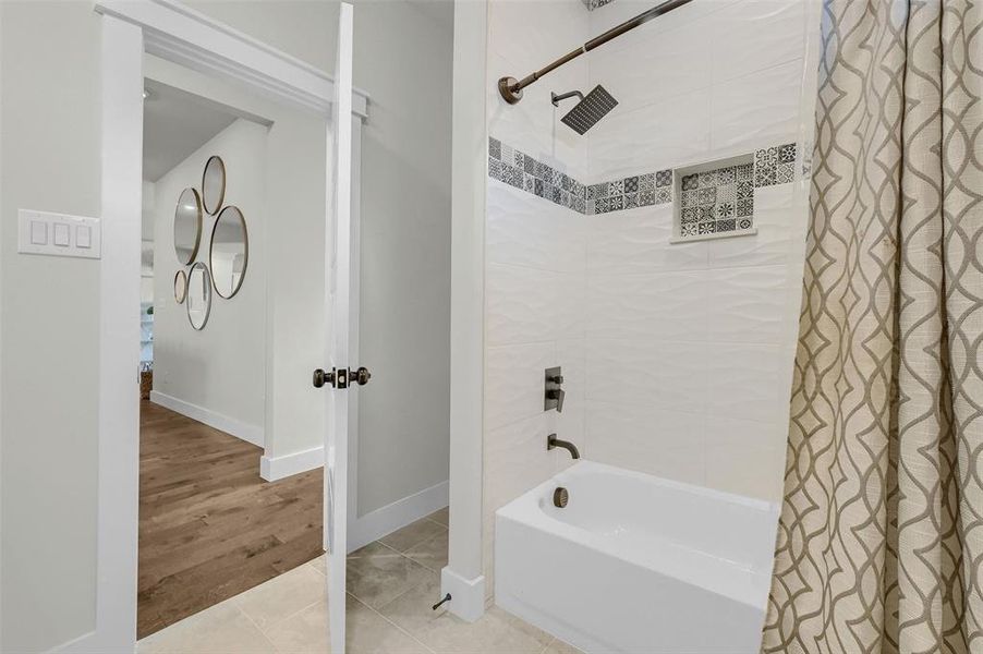 Bathroom with shower / tub combo and tile patterned flooring