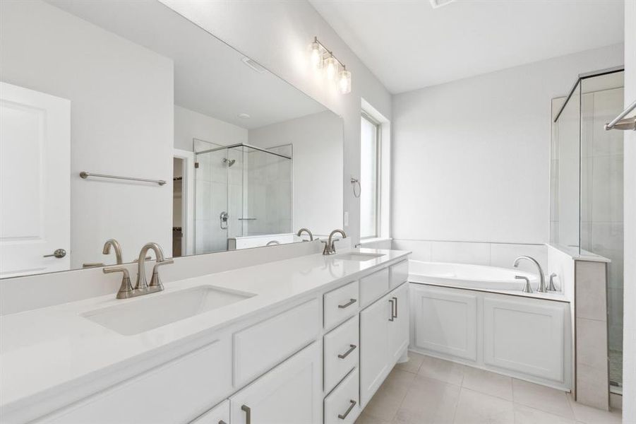 Full bathroom with a shower stall, double vanity, a garden tub, and tile patterned floors Full bathroom with a shower stall, double vanity, a garden tub, and tile patterned floors