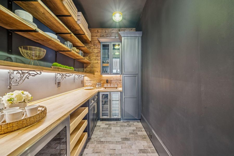 Have you ever seen a pantry like this? A pocket door separates it from the kitchen. Beverage fridge and glass cabinets for your barware.