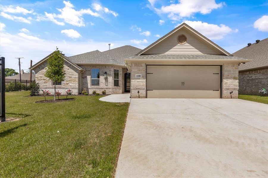 Ranch-style home with a garage and a front lawn