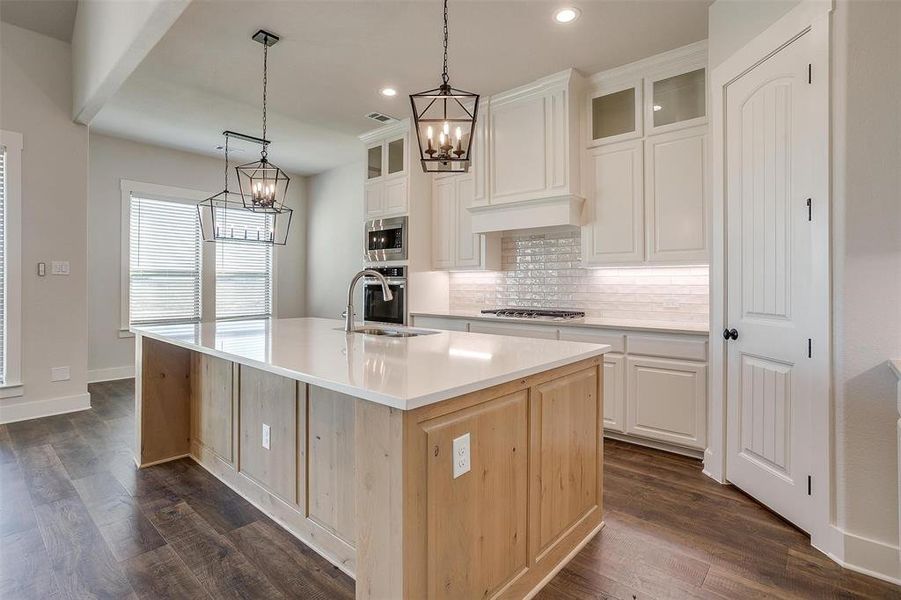 Kitchen with sink, dark hardwood / wood-style flooring, an island with sink, and appliances with stainless steel finishes