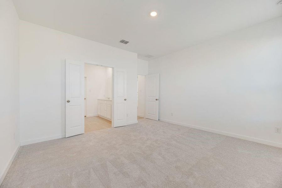 Unfurnished bedroom with light colored carpet and recessed lighting Unfurnished bedroom with light colored carpet and recessed lighting