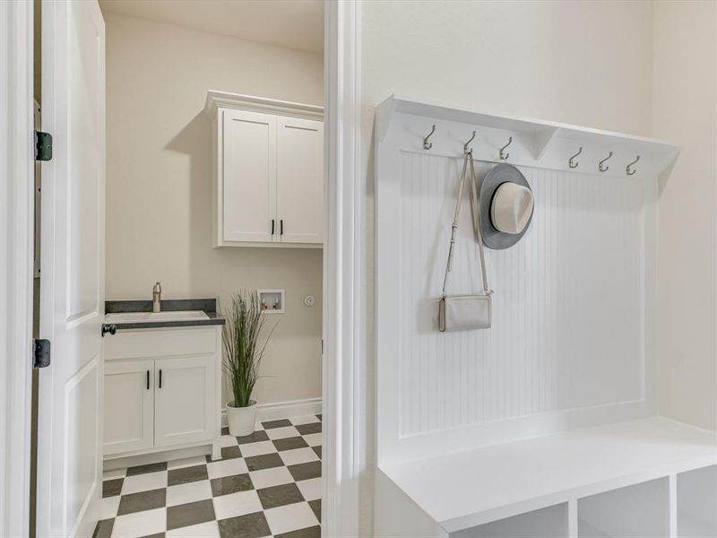 A spacious laundry room is located right off the back hall (garage entrance) with extra cabinetry and sink.