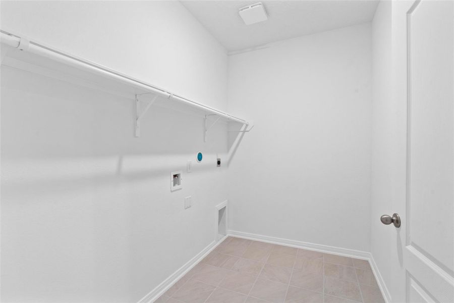 Beyond the kitchen is the laundry room which features a streamlined shelf to keep all your essentials neatly within reach.