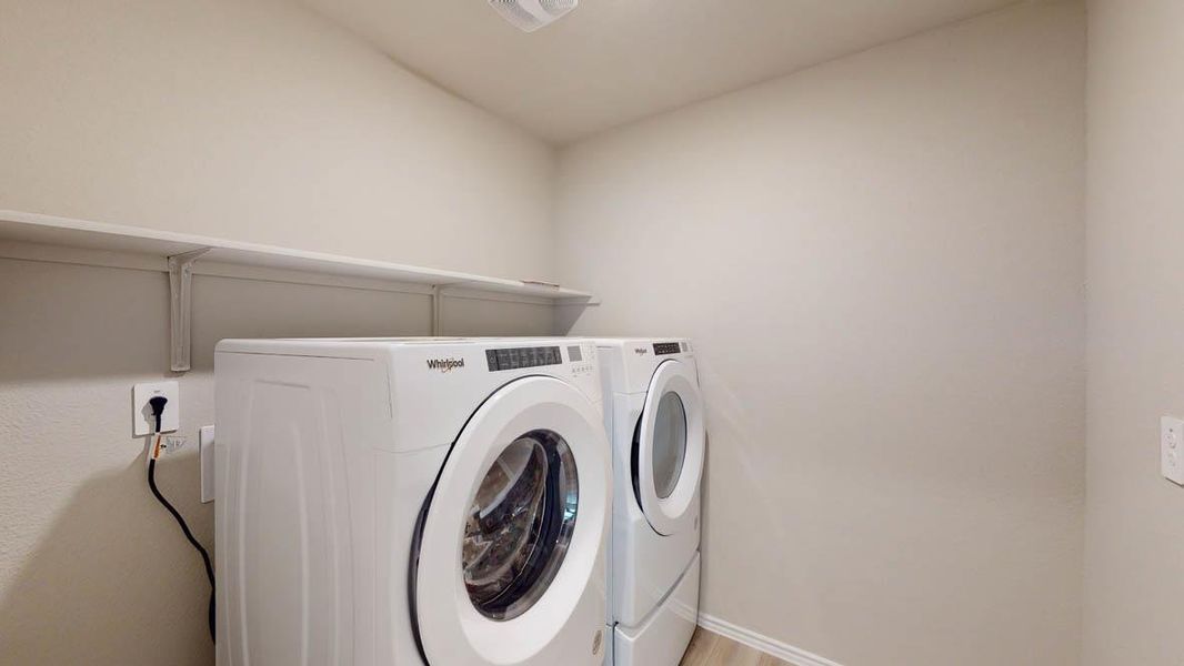 Washroom featuring independent washer and dryer and baseboards