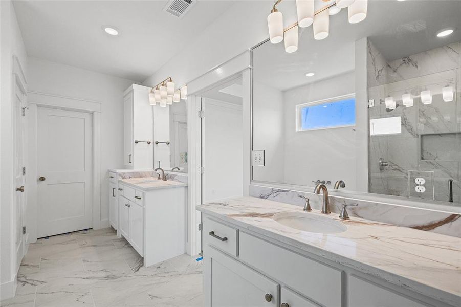 Dual vanity with white cabinetry and integrated sinks, complemented by light-toned, veined countertops