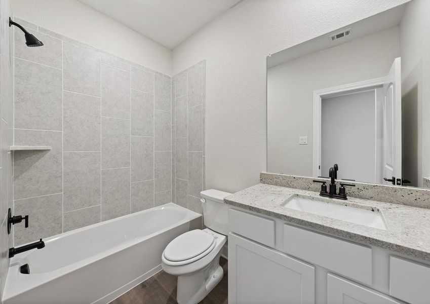 The secondary bathroom of the Sabine floor plan has a vanity space and a shower-tub combo.