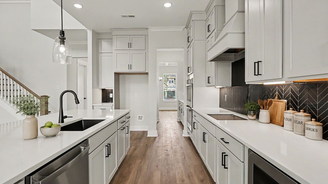 Kitchen with quartz countertops, pendant lighting, and tile backsplash Kitchen with quartz countertops, pendant lighting, and tile backsplash