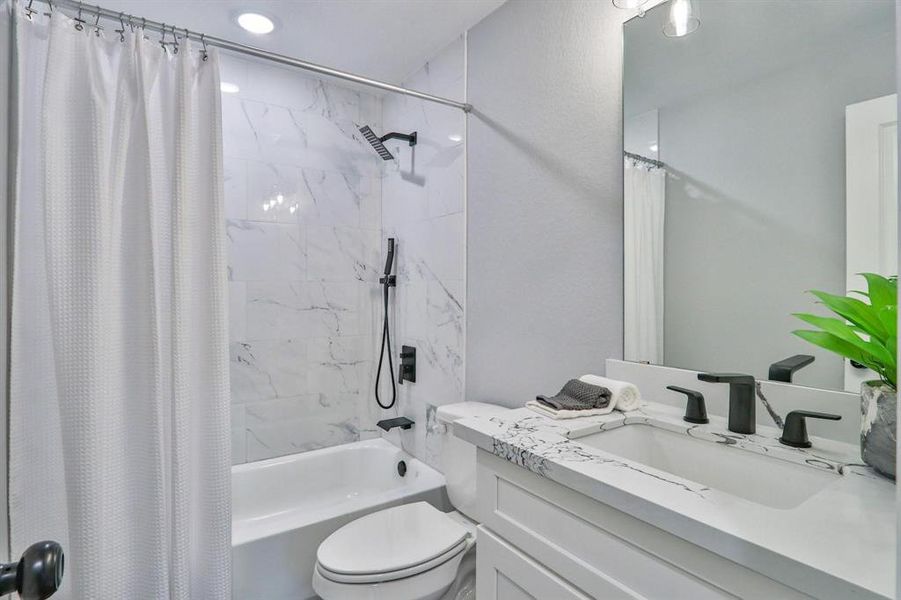 Full size bathroom on the second level features upscale bathtub/shower combo fixtures with oversized showerhead and removal handle for convenience. Quartz countertops and ceramic tile surrounding tub/shower combo.