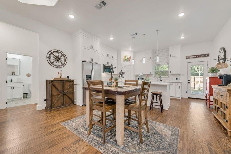 Dining room with light wood-type flooring and recessed lighting