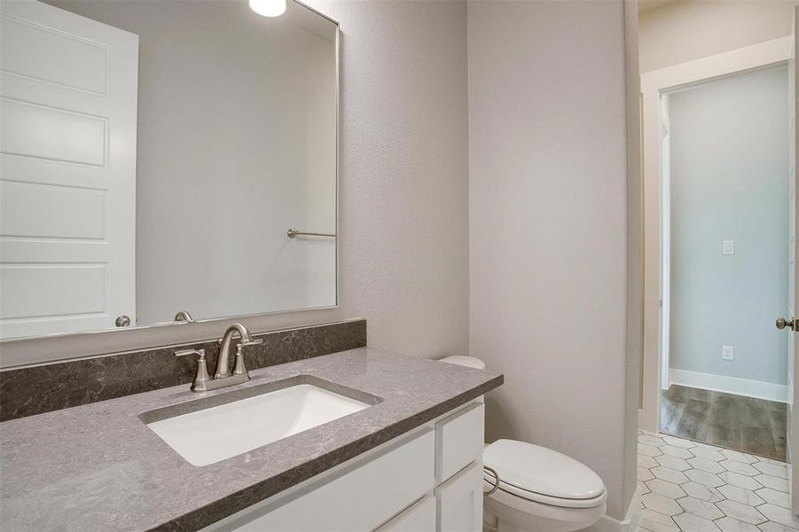 Bathroom featuring tile flooring, large vanity, and toilet