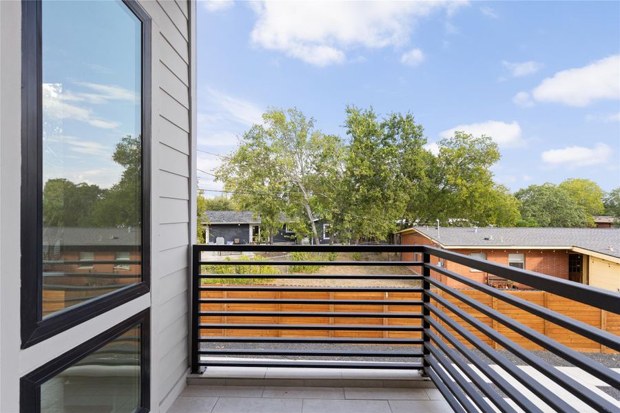An elevated private balcony provides open views over the neighborhood trees.