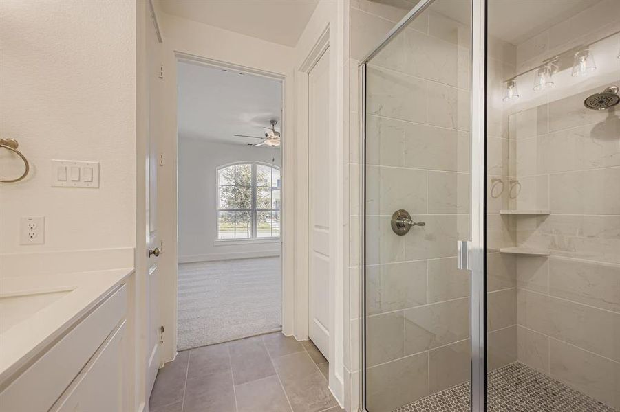 Bathroom featuring vanity, a stall shower, light carpet, light tile patterned floors, and a ceiling fan