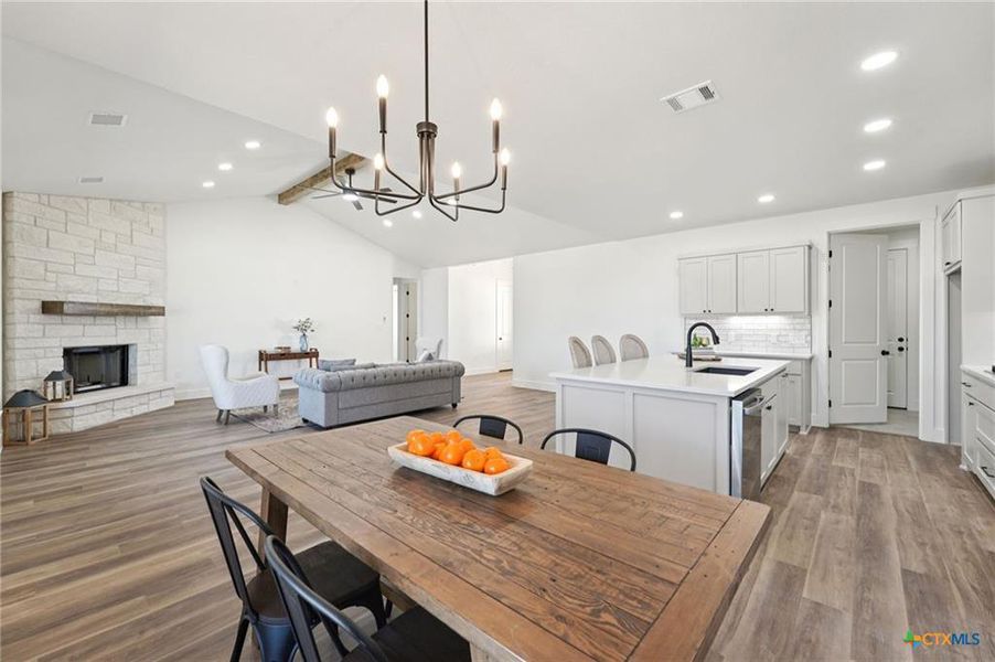 A spacious, open-concept living area with vaulted ceilings and a charming stone fireplace. A spacious, open-concept living area with vaulted ceilings and a charming stone fireplace.