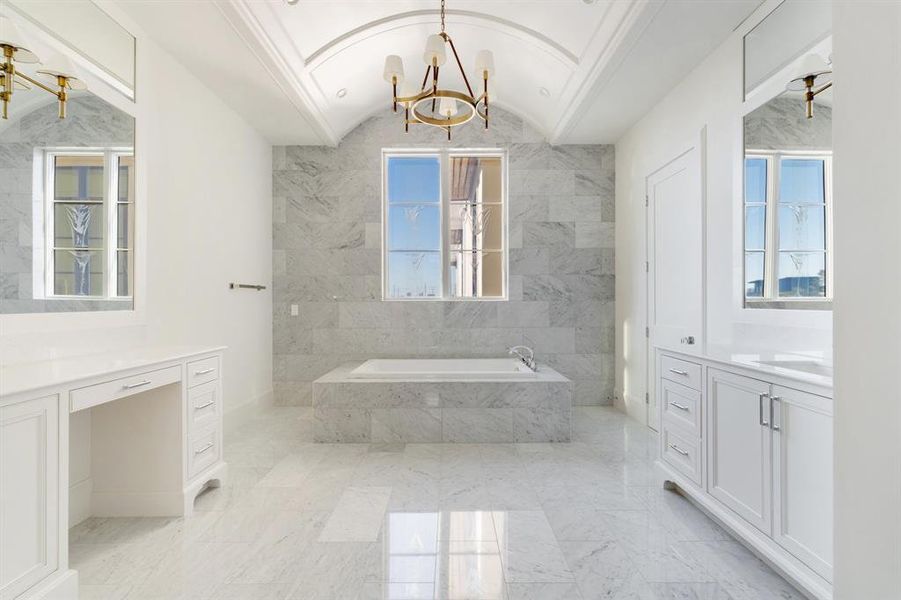 The standout features of the primary spa-suite include extensive marble cladding and a stunning barrel vault ceiling with designer chandelier. (photo of interior model home with smaller floor plan)