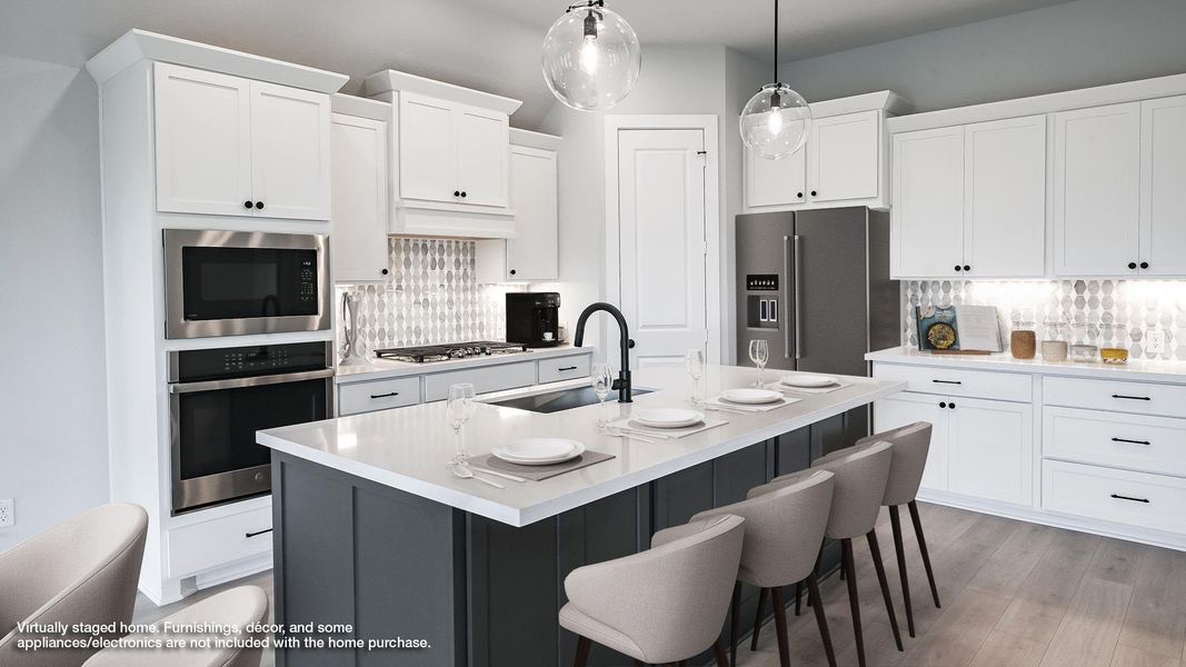 Kitchen featuring backsplash, a center island with sink, appliances with stainless steel finishes, and white cabinets