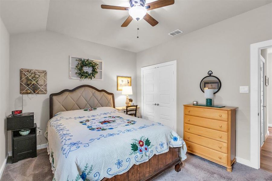 Bedroom with carpet flooring, ceiling fan, vaulted ceiling, and a closet