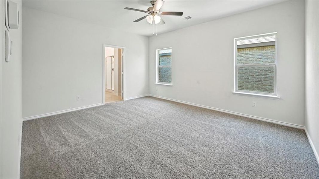Unfurnished bedroom with carpet flooring, ceiling fan, and connected bathroom