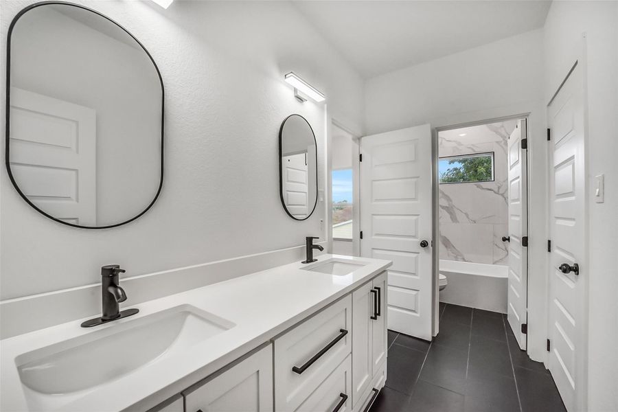 Thoughtfully designed shared bath (Bedroom 2 and Bedroom 3) featuring sleek finishes and a private shower and tub area.