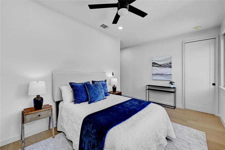 Bedroom featuring light wood-type flooring, ceiling fan, and recessed lighting