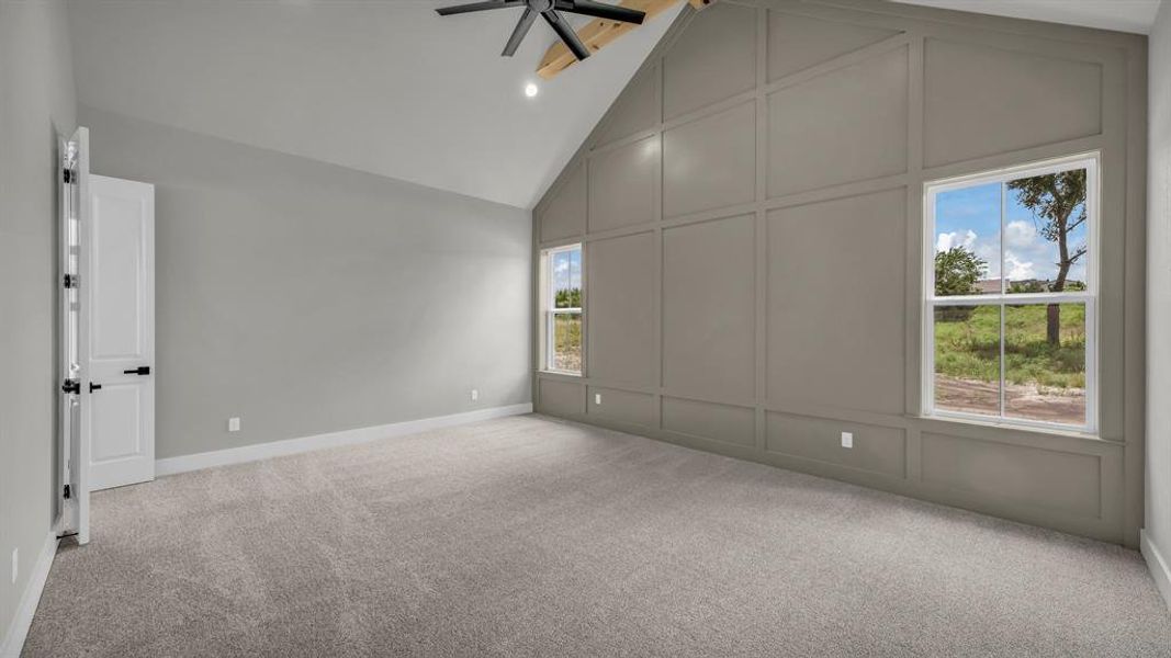 Vaulted ceiling with an exposed wood beam, contemporary ceiling fan, and recessed lighting