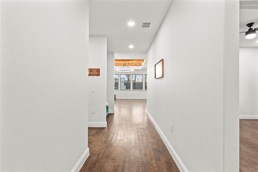 Hallway with dark wood-style flooring and recessed lighting