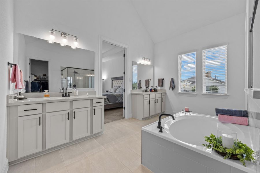 Indulge in a tranquil retreat featuring dual vanities, a spacious soaking tub, and vaulted ceilings. Indulge in a tranquil retreat featuring dual vanities, a spacious soaking tub, and vaulted ceilings.