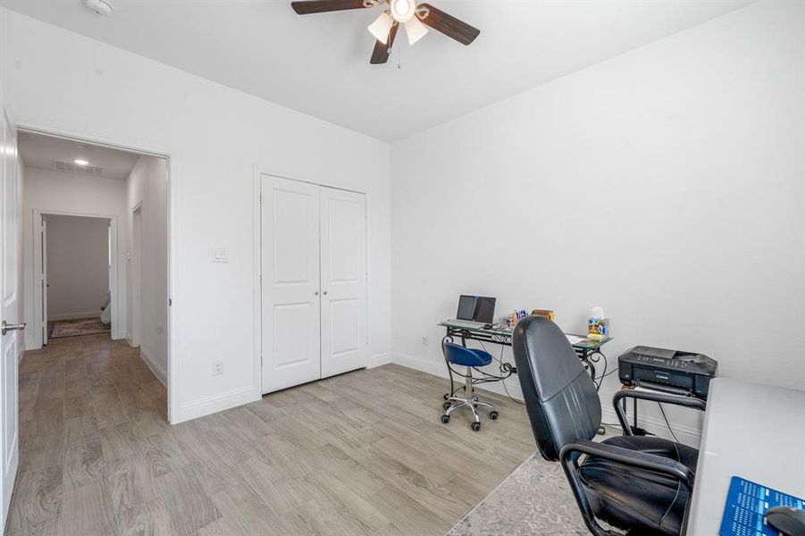 Office area featuring light wood-type flooring and a ceiling fan