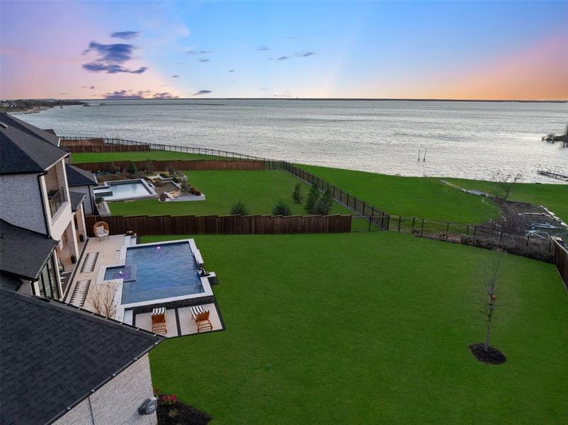 Expansive half-acre homesite showcasing breathtaking sunset views over Lake Lewisville. The oversized backyard offers endless possibilities for outdoor living while capturing panoramic lake vistas, creating a rare setting that blends luxury living with the beauty of lakeside sunsets.