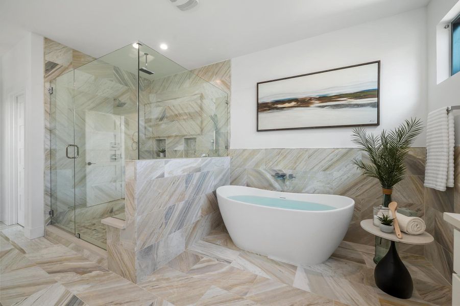 Bathroom featuring a soaking tub, tile walls, and a stall shower