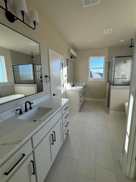 Bathroom with tile patterned flooring, vanity, and walk in shower