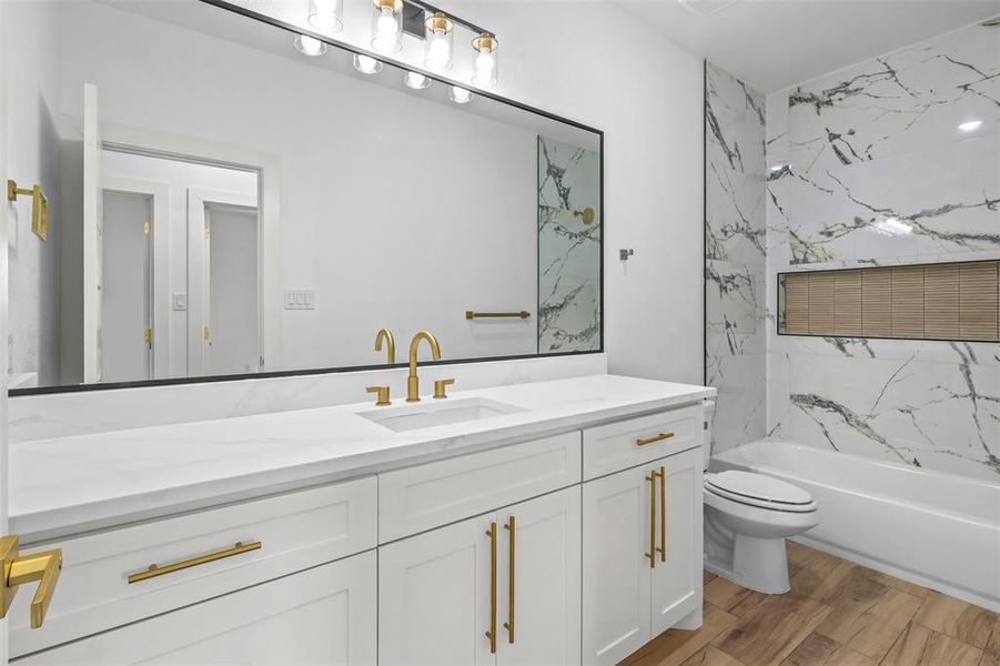 Bathroom with vanity, light wood-style flooring, and shower / bathtub combination