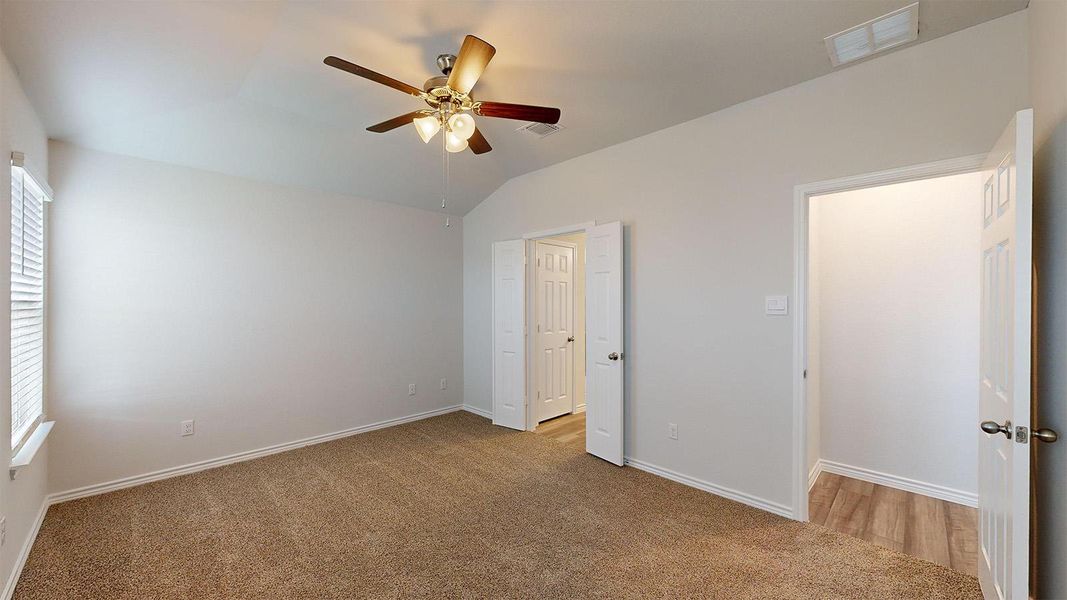 Unfurnished bedroom with carpet floors, lofted ceiling, and ceiling fan