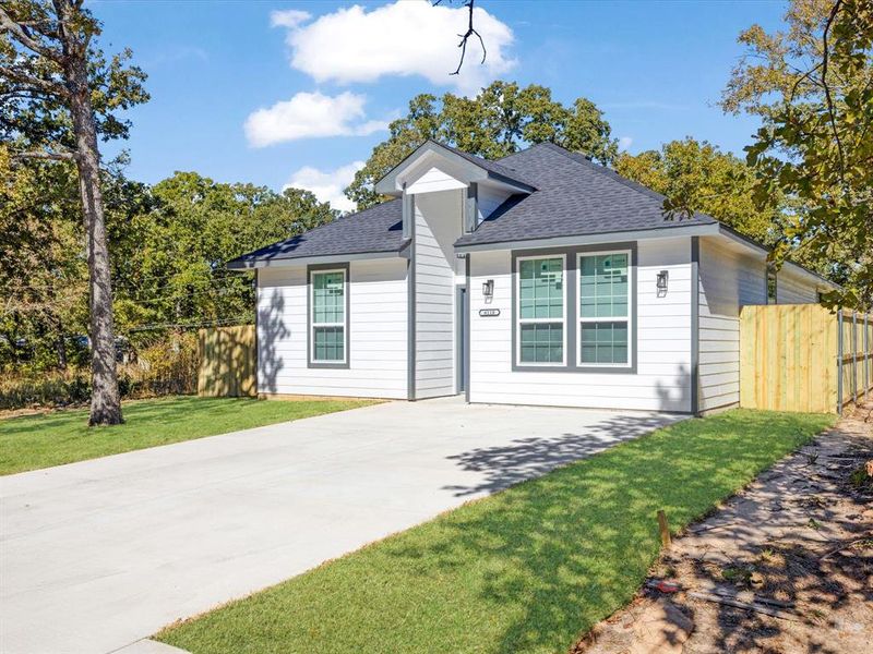 View of front of home with roof with shingles and concrete driveway
