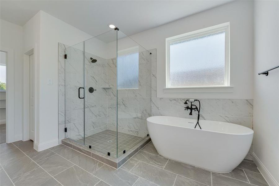 Bathroom featuring tile patterned flooring, a wealth of natural light, and tile walls